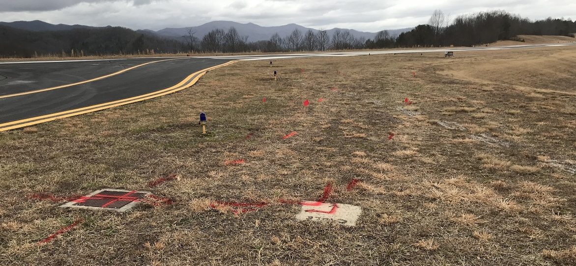 Red marks on ground depict electrical lines for runway lighting.