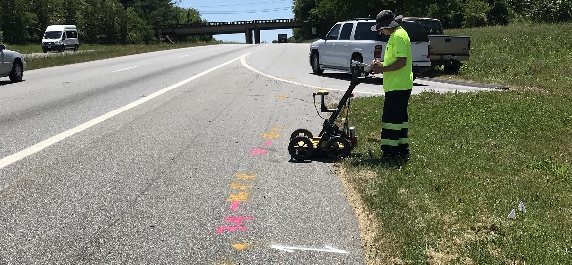 Technician recording GPR data next to busy interstate