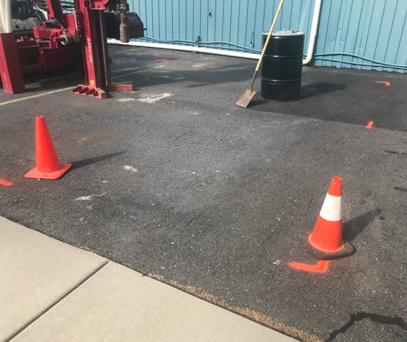 Marks on pavement outside a building for borehole clearance