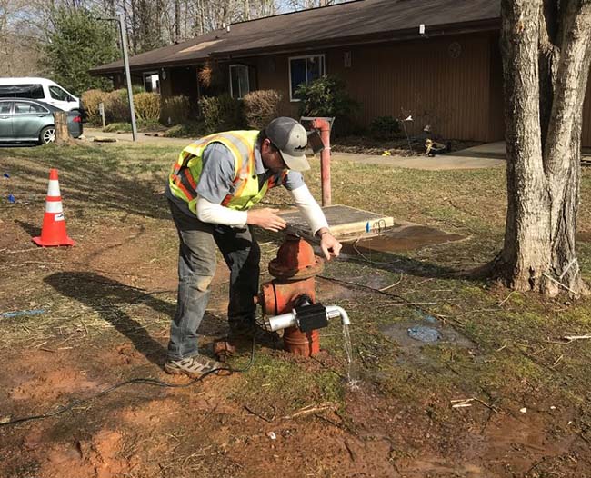 Technician connecting leak detection equipment to fire hydrant