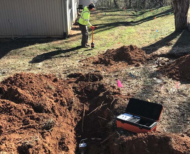 Technician using electro-acoustic leak detection equipment.